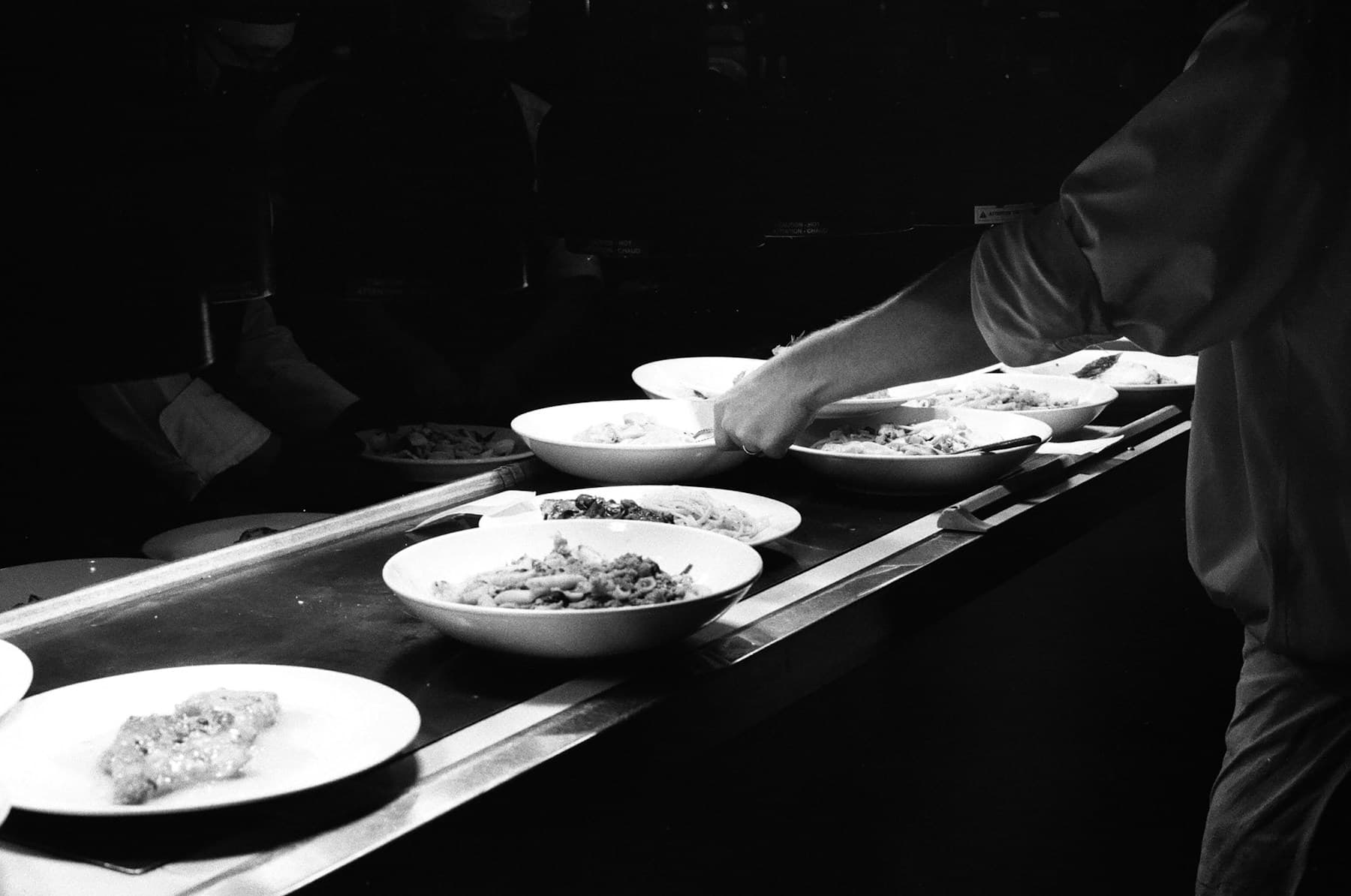 Restaurant dishes moving across a kitchen pass